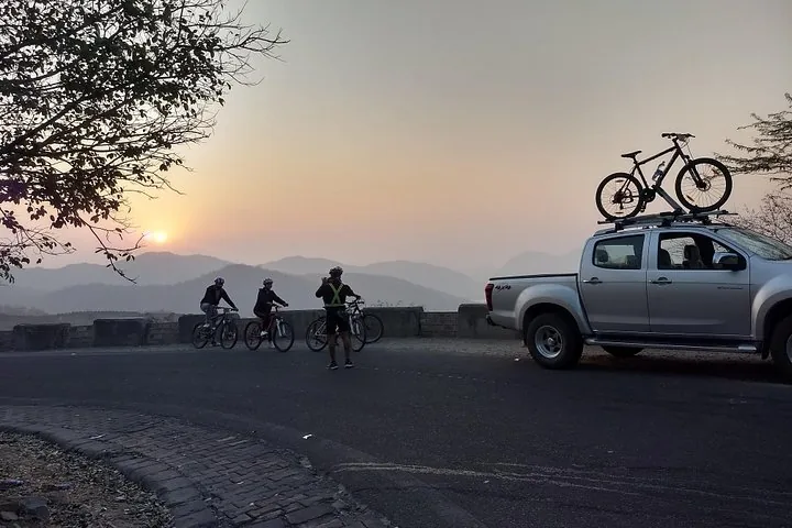 Cyclists taking a break with a view of the mountains at sunset.